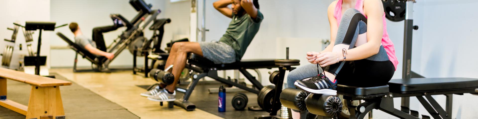 Studierende machen Krafttraining in einem Wohnheimtrainingsgeräteraum.