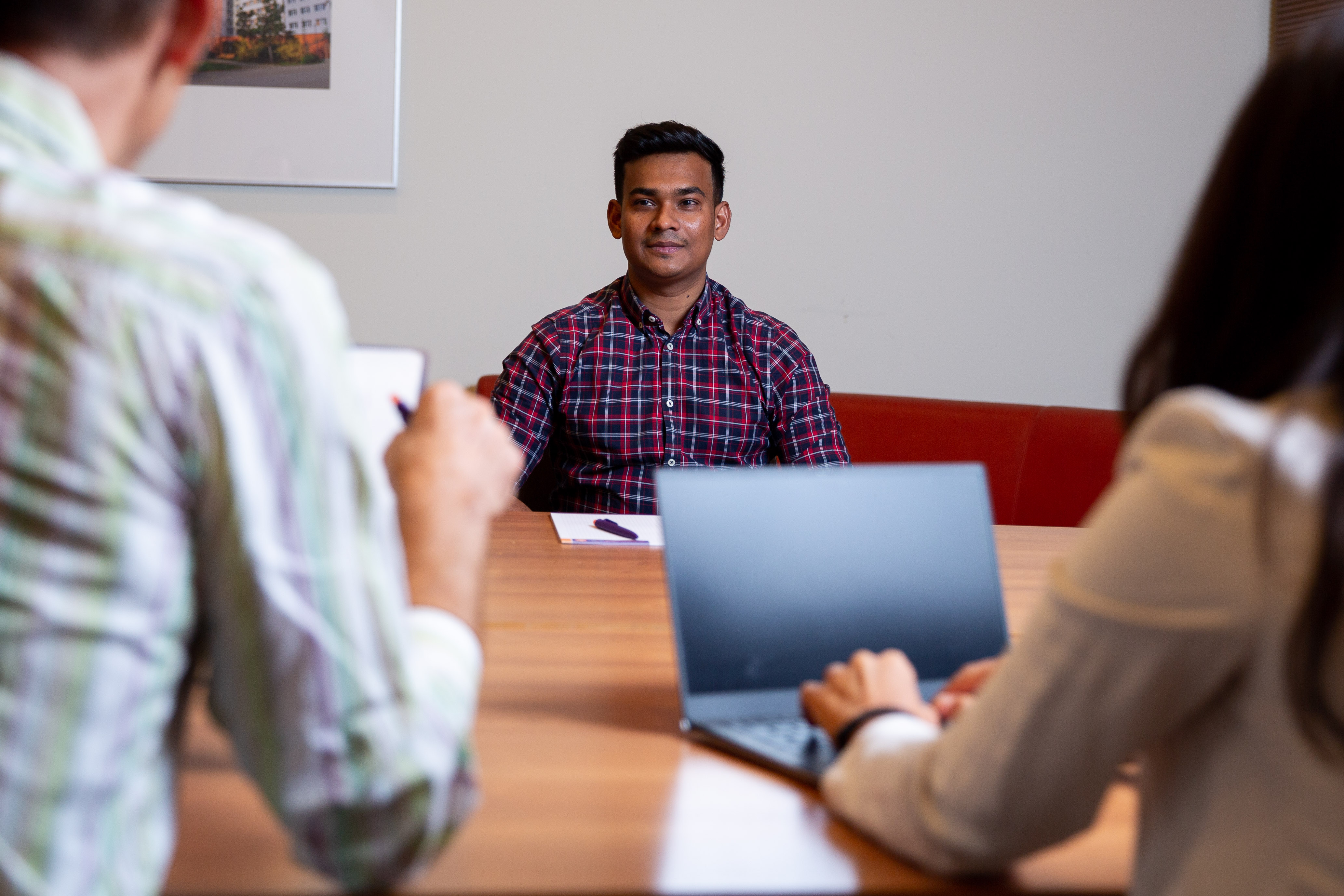 Student being interviewed in a conference room by two faculty members.