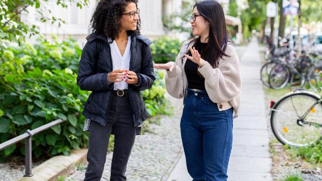 Two people standing and talking to each other.