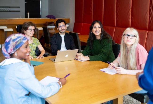 picture shows five students in an engaged discussion 