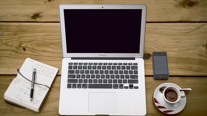 Desk with PC, notebook, smartphone and a coffee.