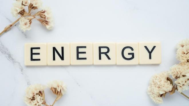 Scrabble stones that form the word "energy" with fllowers surrounding them